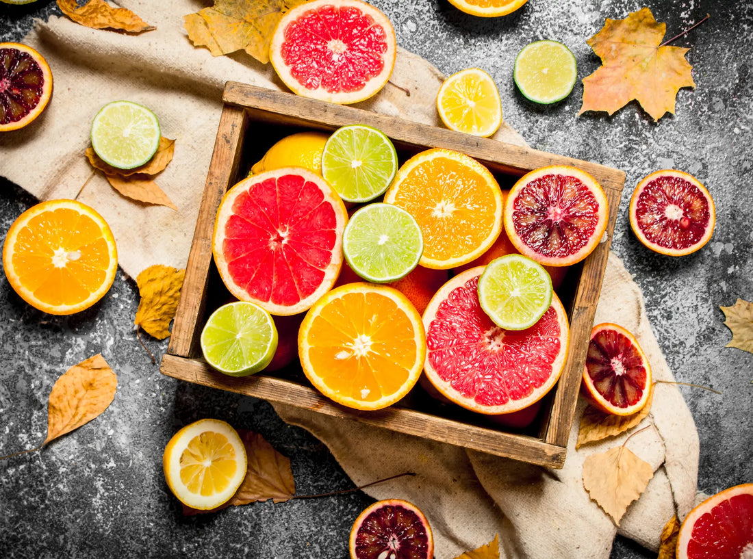 Assorted citrus fruits, including oranges, lemons, limes, and grapefruits, arranged in a crate on display.