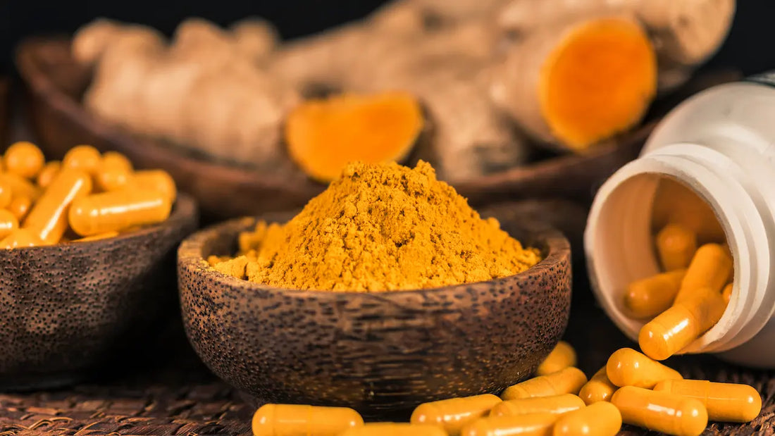 Curcumin powder and supplements with turmeric root on a slate table, offering potential health benefits for longevity.