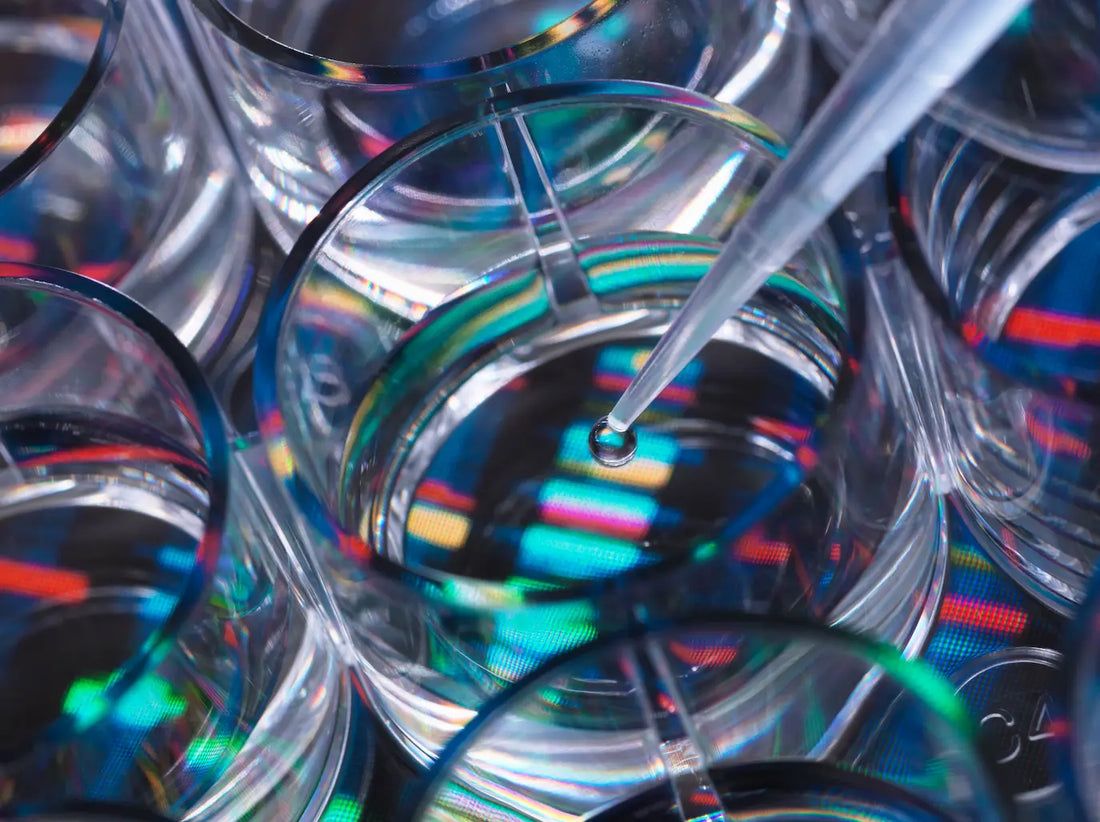 A pipette dispensing liquid into a test tube, with chromatography scripts in the background.